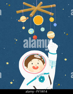 Enfant en costume d'astronaute et pointant sur la planète figure Banque D'Images