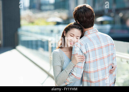 Couple hugging les uns les autres avec les yeux de la femme à l'extérieur fermé Banque D'Images