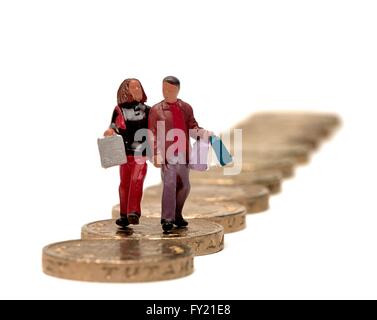 Un petit couple carrying shopping bags walking sur pièces livre Banque D'Images