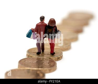 Un petit couple carrying shopping bags walking sur pièces livre Banque D'Images