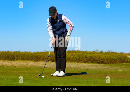 Skanor, Suède - 11 Avril 2016 : femme jeune adulte golfeur préparant son swing sur tee. Elle est se concentrer et à se concentrer sur ses Banque D'Images