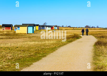 Skanor, Suède - 11 Avril 2016 : sont dehors pour une promenade sur le sentier de randonnée par la plage face par beaucoup de de cabines Banque D'Images