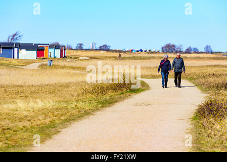 Skanor, Suède - 11 Avril 2016 : sont dehors pour une promenade sur le sentier de randonnée par la plage face par beaucoup de de cabines Banque D'Images