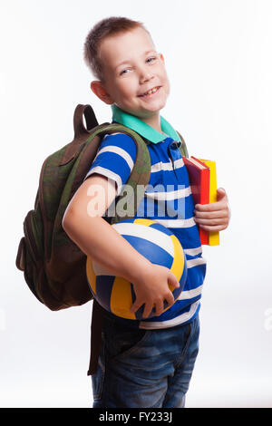 Écolier heureux avec sac à dos, ball et livres isolé sur fond blanc Banque D'Images