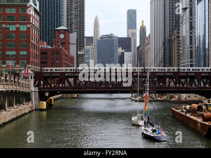 Voiliers d'attendre un train surélevé CTA pour effacer le Wells Street Bridge comme ils font leur chemin jusqu'à la rivière Chicago à Chicago Banque D'Images