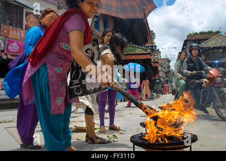 Les dévots attisant un feu rituel près de Kasthamandap temple à Durbar Square - Katmandou, Zone Bagmati, Vallée de Katmandou, Népal Banque D'Images