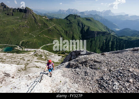 L'ordre croissant à l'alpiniste sur la Punta Serauta Via Ferrata Eterna dans Marmolada, ci-dessous la, derrière le col Fedaia Banque D'Images