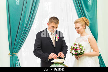 Le marié de glisser sur le doigt de l'anneau de mariage à la mariée Banque D'Images