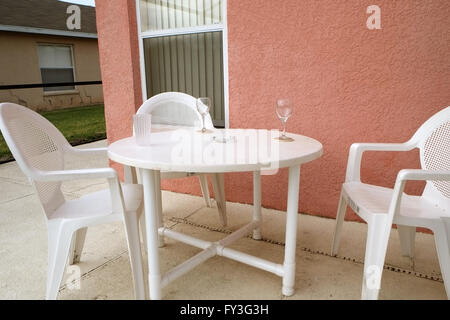 Tables et chaises en plastique blanc à l'extérieur une piscine Floride accueil utilisé pour location de vacances. 19 avril 2016 Banque D'Images
