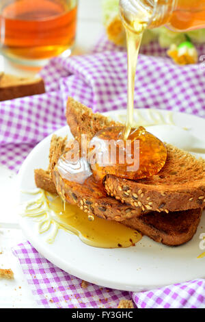 Verser le miel sur toast - petit déjeuner Banque D'Images