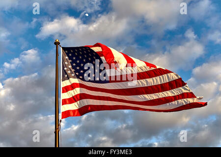 Drapeau américain sur mât agitant au vent contre les nuages, ciel bleu et la lune Banque D'Images