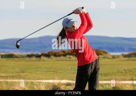 Jeune femme jouant le golf et balançant un chauffeur, Royal Troon, Golf Club, Ayrshire, Scotland, UK Banque D'Images