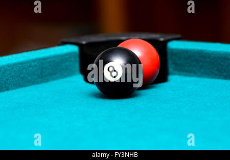 Huit boule et boule rouge sur une table de billard Banque D'Images