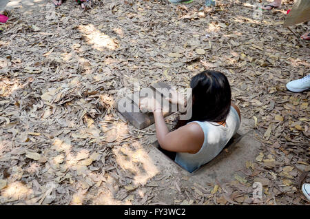 Les gens voyagent et essayer de jouer la saisie au tunnel Tunnels de Cu Chi à Ho Chi Minh, Vietnam Banque D'Images