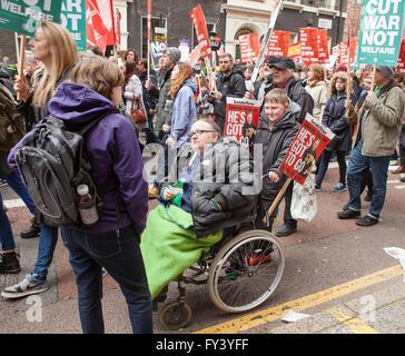 Une personne handicapée, aidé par son fils, participe à la lutte anti-austeritymarch à Londres, pour protester contre les coupures à mobilité avantages. Banque D'Images