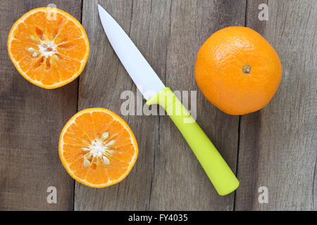 Mandarines et couteau acrylique placé sur l'ancien plancher en bois,concept design pour sur les aliments de santé. Banque D'Images