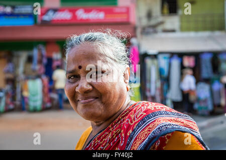 Dame indienne en marchant le long de la route de Kuilapalayam regarde la caméra et sourit Banque D'Images