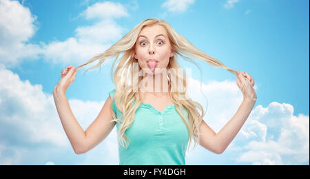 Happy young woman showing langue maternelle et la tenue d'un sèche Banque D'Images