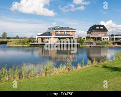 Maisons au bord de l'eau vert en banlieue résidentielle, Almere dans la province de Flevoland près d'Amsterdam Banque D'Images