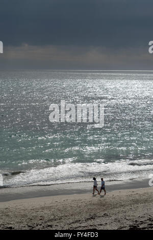 Couple en train de marcher sur la plage de Cottesloe avec Storm Brewing, Ville de Perth, Australie occidentale. Banque D'Images