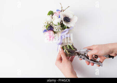 Un fleuriste prépare un bouquet de tulipes roses, violettes, muscaris anémones blanc, violet et blanc veronica buttercup wit Banque D'Images
