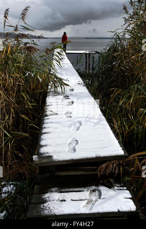 Personne debout à la fin d'un quai couvert de neige, Chiemgau Haute-bavière Allemagne Europe Banque D'Images