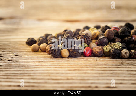 Mélange de poivre sec macro sur fond de bois Banque D'Images