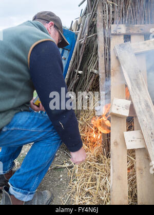 Un homme d'allumer un feu de camp feu de balise pour le 90e anniversaire de la reine à Whitwell, île de Wight, Royaume-Uni Banque D'Images