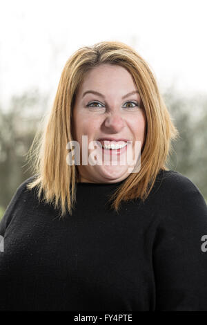 Classic Head Shot. Une jeune femme d'un haut noir et de courts cheveux blonds se trouve à l'extérieur retour éclairé par le soleil. Elle est très à l'UMA Banque D'Images