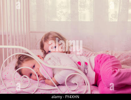 Peu de jolies filles (soeurs) Jouer au lit. Focus sélectif. Banque D'Images