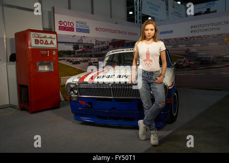 Crocus Expo à Moscou, Moscou, Russie - 15 Avril 2016 : jeune fille se tient près de la vieille voiture au Photoforum 2016 Banque D'Images