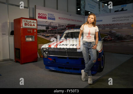 Crocus Expo à Moscou, Moscou, Russie - 15 Avril 2016 : jeune fille se tient près de la vieille voiture au Photoforum 2016 Banque D'Images