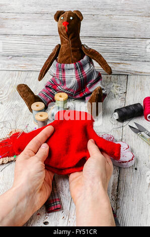 Mains sur mesure dans le processus de la fabrication de jouets et d'ours outils de couture Banque D'Images