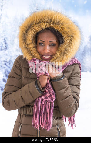 Beautiful smiling African femme portant un manteau de fourrure et capuche sur la neige en hiver jour Banque D'Images