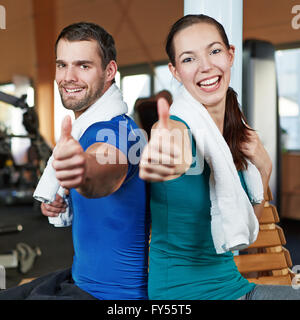 Smiling happy couple holding les pouces jusqu'à un centre de remise en forme Banque D'Images