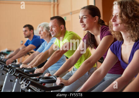 Groupe mixte équitation vélos dans spinning class in fitness center Banque D'Images