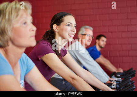 Young happy woman riding spinning bike dans un centre de remise en forme Banque D'Images