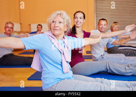 Senior woman doing gymnastics exerce en retour Cours de formation en salle de sport Banque D'Images