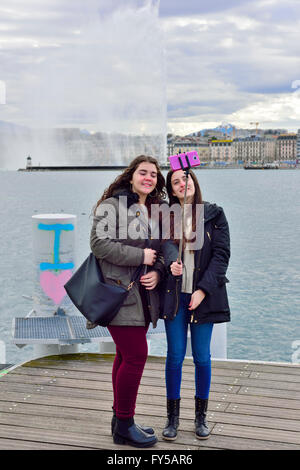 Deux femmes prenant une photo avec les selfies Genève jet d'eau fontaine sur le lac en arrière-plan Banque D'Images