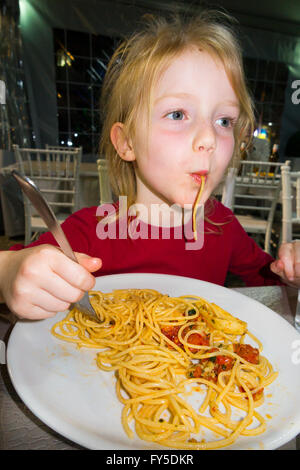 Jeune fille enfant / kids pour enfants âgés de 5 - 6 ans manger authentique authentique dans le restaurant spaghetti pâtes italiennes à Naples Italie Banque D'Images