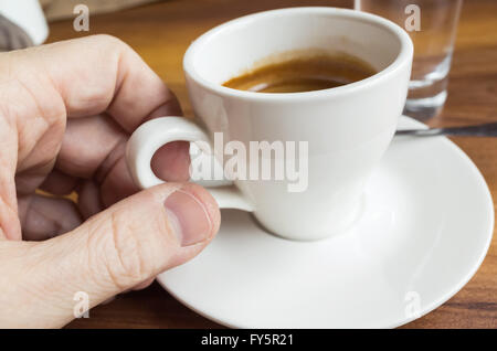 La main des hommes en tenant expresso avec petite tasse blanche Banque D'Images