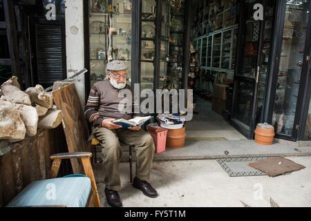 (160422) -- LE CAIRE, Avril 22, 2016 (Xinhua) -- Mahamoud Sabry, un 81-year-old woman, lit le Coran devant son magasin de souvenirs, Le Caire, Egypte, 9 mars 2016. Mahamoud Sabry persiste dans la lecture tous les jours. En plus de finir la lecture de l'ensemble du Coran tous les 6 jours, il lit aussi les livres sur la poésie, l'histoire et la politique. La 21e Journée mondiale du livre arrivera le samedi. "Un livre est un lien entre le passé et l'avenir. C'est un pont entre les générations et entre les cultures. C'est une force de création et de partage de connaissances et de sagesse." a déclaré le directeur général de l'UNESCO, Irina Bokova. L'arrière Banque D'Images