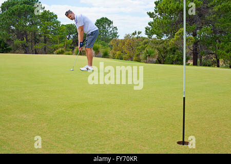 Jeune golfeur mettre vers le trou. Le Golf. Banque D'Images