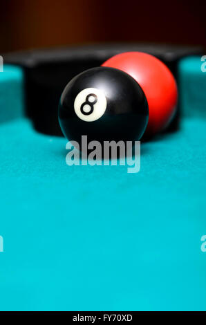 Huit boule et boule rouge sur une table de billard Banque D'Images