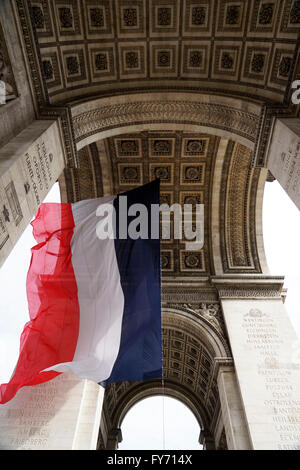 Drapeau national en vertu de l'Arc de Triomphe, Paris, France Banque D'Images