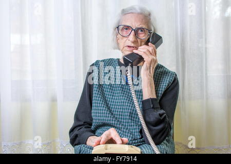 90 ans femme femme en utilisant le téléphone à l'intérieur Banque D'Images