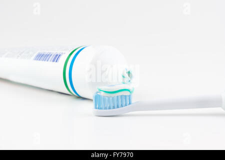 Tube de dentifrice avec une petite quantité de dentifrice sur une brosse à dents Banque D'Images