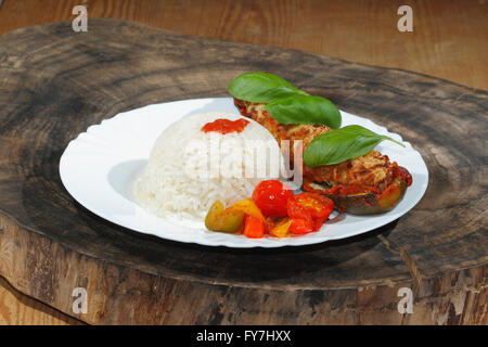 Courgette farcie, riz, compotée de poivrons et tomates, légumes, salade et décorer avec des feuilles de basilic sur une plaque Banque D'Images