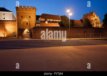 Torun, Pologne, pont médiéval Gate (Polonais : Brama Mostowa) et mur de la ville la nuit, la fortification de la Vieille Ville Banque D'Images