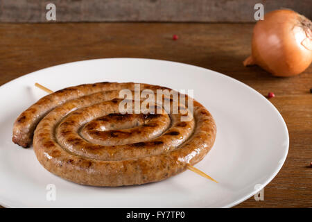 Saucisses grillées en spirale sur une plaque blanche Banque D'Images